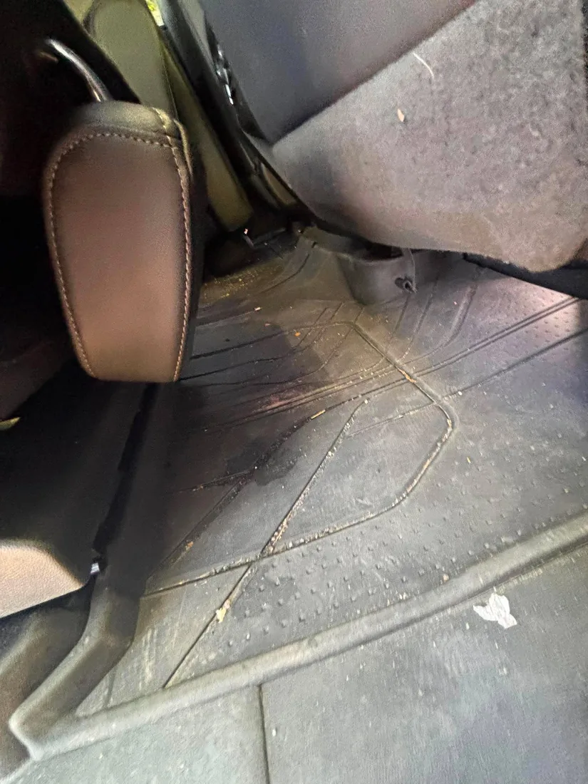 Rear footwell before — muddy mat and stained seat back